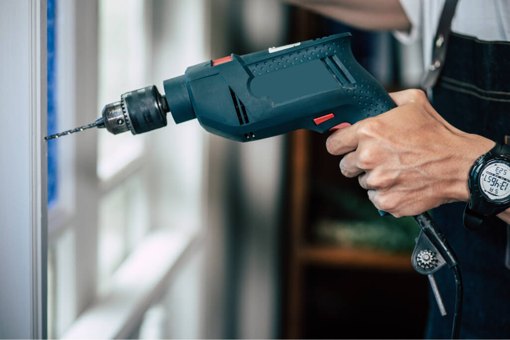 The carpenter holds the drill and drills the windo 2021 08 31 12 07 23 utc.jpg